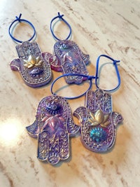 four hamsa hand ornaments on a table