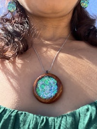 a woman wearing a necklace and earrings