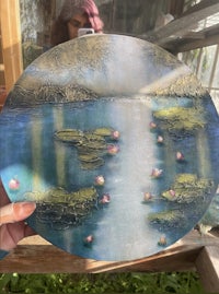 a person is holding up a plate with water lilies on it