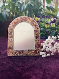 a small mirror with a flower on it
