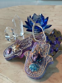a hamsa hand on a table next to a lotus flower