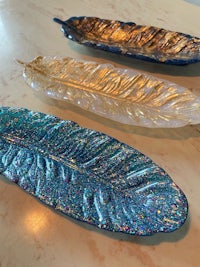 three glass feather trays on a table
