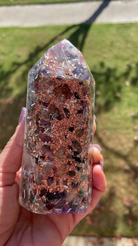a person holding an amethyst crystal in their hand