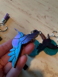 a person holding a hummingbird key chain