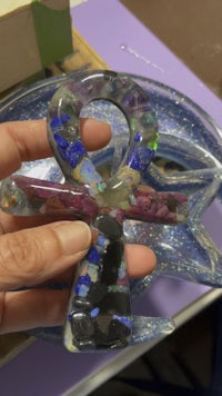 a person holding a glass ankh