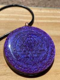 a blue and purple glitter pendant on a wooden table