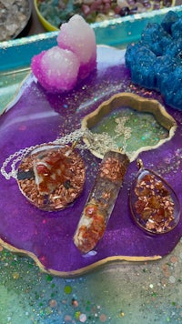 a tray with a variety of necklaces and crystals on it
