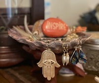 a hamsa hand on a shell with a hamsa necklace