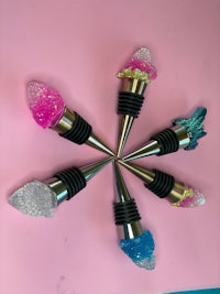 a group of wine stoppers with glitter on them