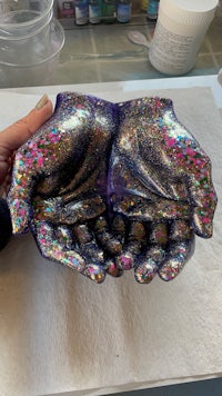 a person holding a glittery hand on a piece of paper