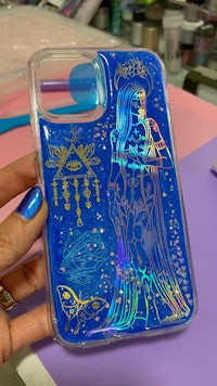 a person holding a phone case with an image of a woman in a blue dress