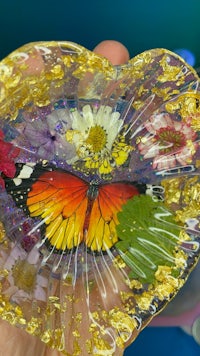 a person holding a glass plate with a butterfly on it