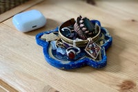 a blue jewelry holder on top of a wooden table