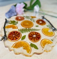 a tray with oranges and ferns on it