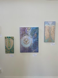 four paintings hanging on a wall in an art gallery